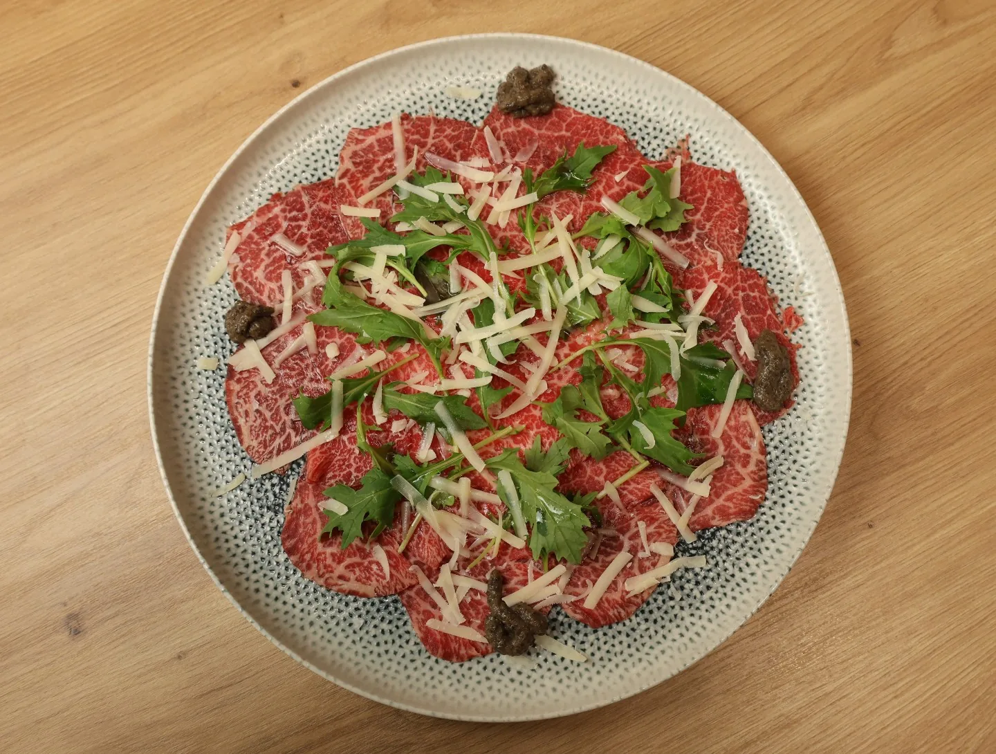 Carpaccio de Wagyu con rúcula y parmesano
