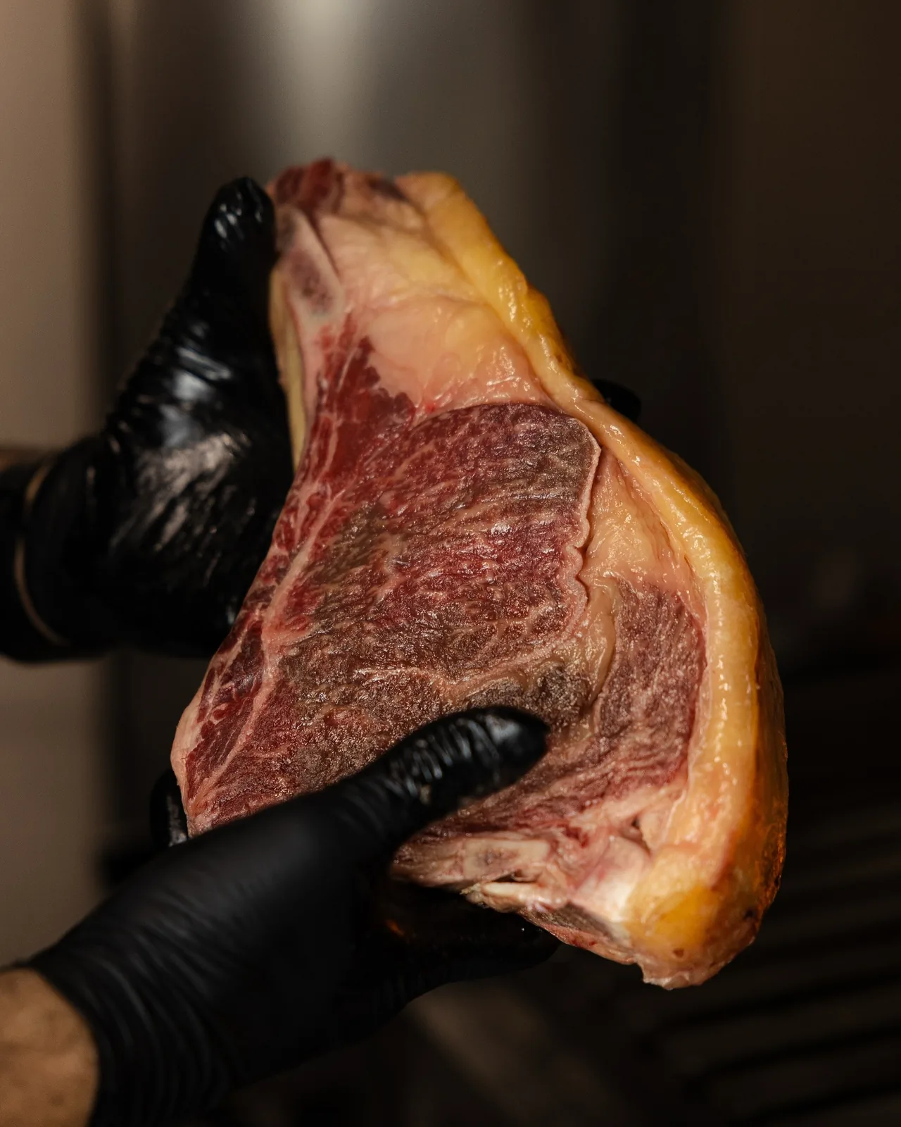 Chuletón madurado sostenido en las manos